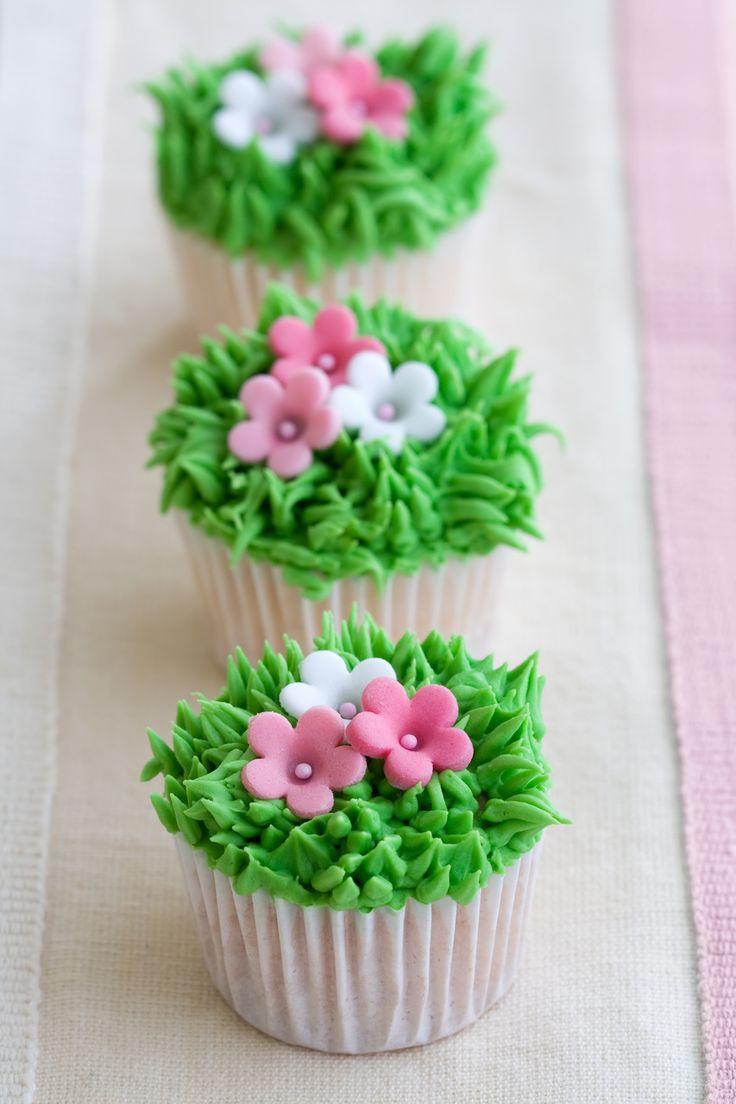 Mini cupcakes decorated with frosted grass and pink flowers